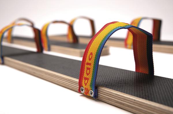 Bunte Tragegriffe an Holzplatten für einfachen Transport, Nahaufnahme auf weißem Hintergrund.