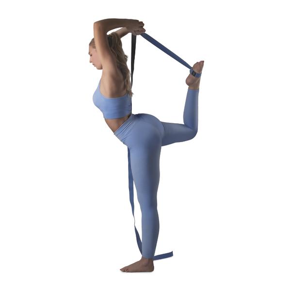 Frau in blauer Sportkleidung macht Dehnübung mit Yoga-Gurt auf weißem Hintergrund.