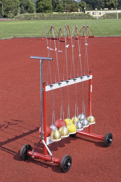 Mobil montierte Kugelstoßkugeln auf roter Laufbahn im Freien.