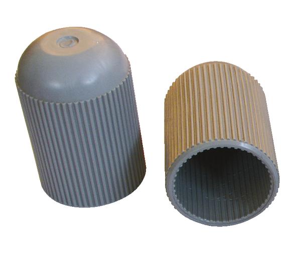 Graue geriffelte Kunststoffkappen, eine stehend und eine liegend, auf weißem Hintergrund.