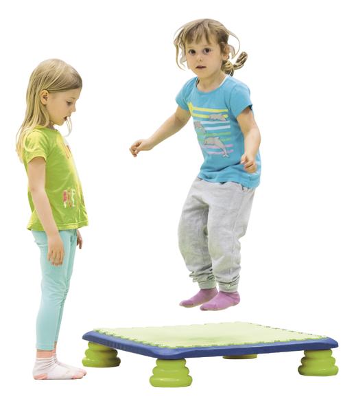 Kind springt auf Trampolin, anderes Kind beobachtet, weißer Hintergrund, Spiel und Bewegung.
