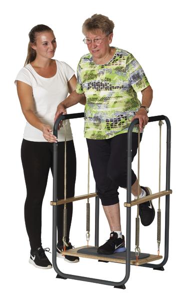 Ältere Frau macht Gehtraining an Rehabilitationsgerät, betreut von junger Physiotherapeutin.