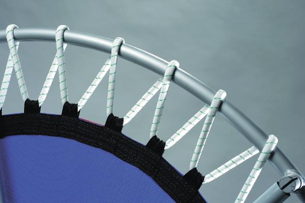 Mini-Trampolin mit elastischen Seilen und blauem Sprungtuch vor grauem Hintergrund.