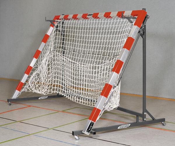 Handballtor mit rotem und weißem Rahmen und Netz in einer Sporthalle auf Rollen.