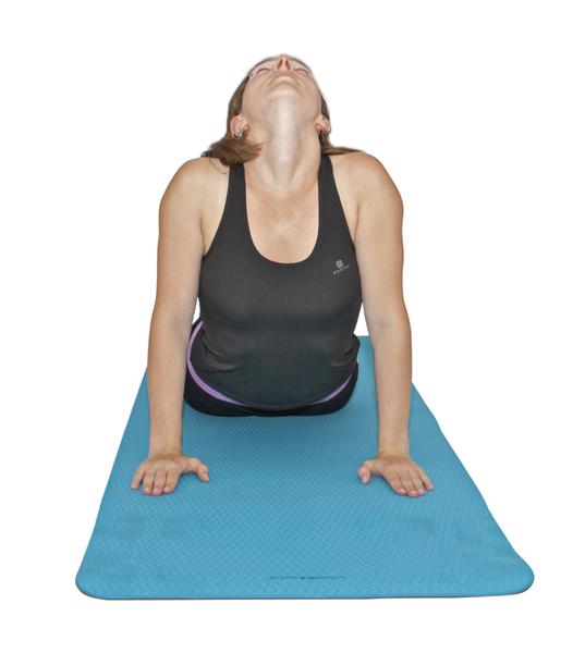 Frau macht Yoga-Übung Kobra auf blauer Matte, Rücken und Nacken gedehnt.