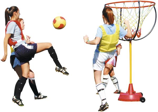 Drei Mädchen spielen Korbball, eine schießt den Ball auf den Korb.