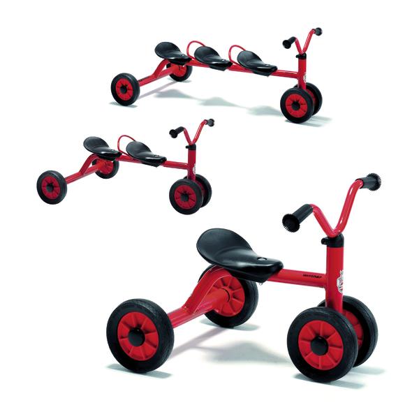 Rotes Dreirad mit drei Sitzen und schwarzen Griffen für Kinder.