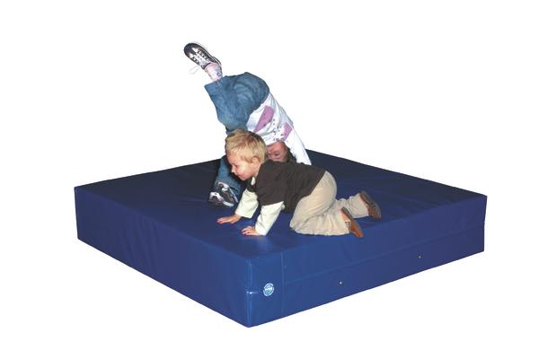 Zwei Kinder spielen auf einer blauen Turnmatte, eines macht einen Handstand.