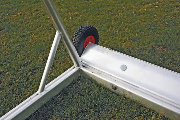 Kippsicherung mit Transportrollen für Fußballtore auf grünem Rasen.