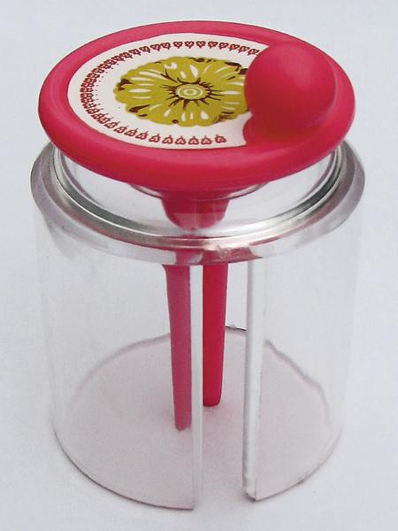 Aufwickelbox für Gynmastikbänder aus durchsichtigem Kuststoff mit rotem Deckel.