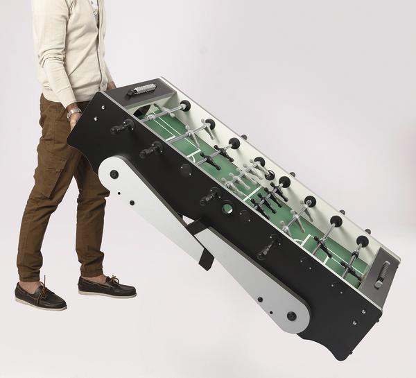 Person kippt einen Kinder-Tischkicker mit Transportrollen zum einfachen Bewege.