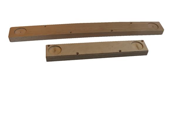 Zwei unterschiedlich lange Holzleisten mit runden Vertiefungen auf weißem Hintergrund.