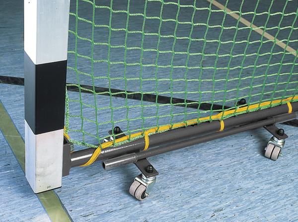 Detailaufnahme eines mobilen Handballtors mit grünem Netz und Rollen auf Hallenboden.