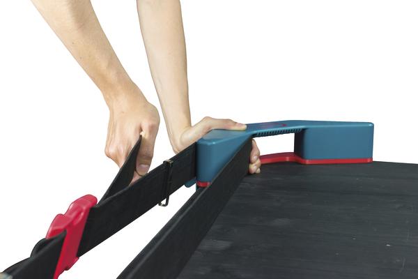 Person spannt Sicherheitsgurt an einem Förderband mit blau-rotem Griff.