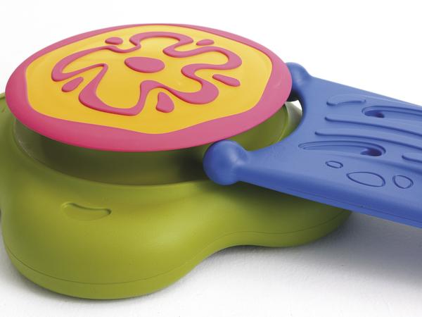 Buntes Kinderspielzeug aus Kunststoff mit grünem, blauem und pink-gelbem Teil auf weißem Hintergrund.