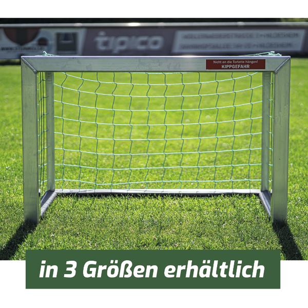 Kleines Fußballtor aus Metall mit Netz auf grünem Rasen, Hinweis auf Kippgefahr.