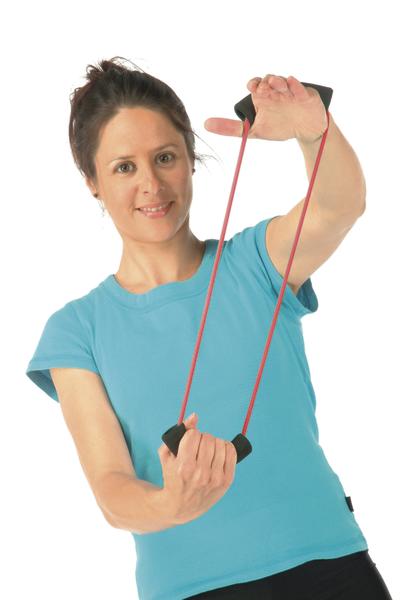 Frau in blauem Shirt trainiert mit rotem Fitnessband vor weißem Hintergrund.