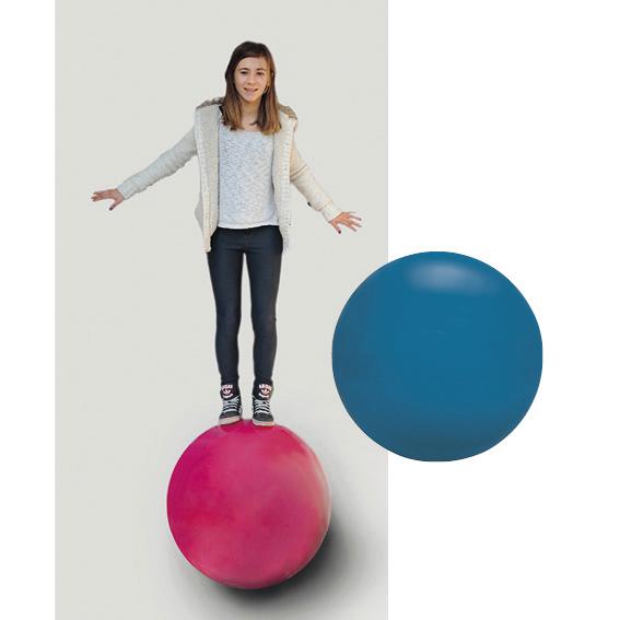 Mädchen balanciert auf großem roten Ball, daneben ein blauer Gymnastikball auf weißem Hintergrund.