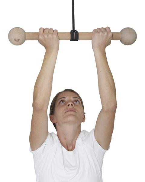 Frau hält Holzgriff an Deckenhalterung für Klimmzüge, weißes T-Shirt, weißer Hintergrund.