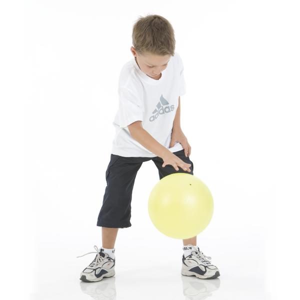Junge in weißem Adidas-Shirt spielt mit gelbem Ball auf weißem Hintergrund.