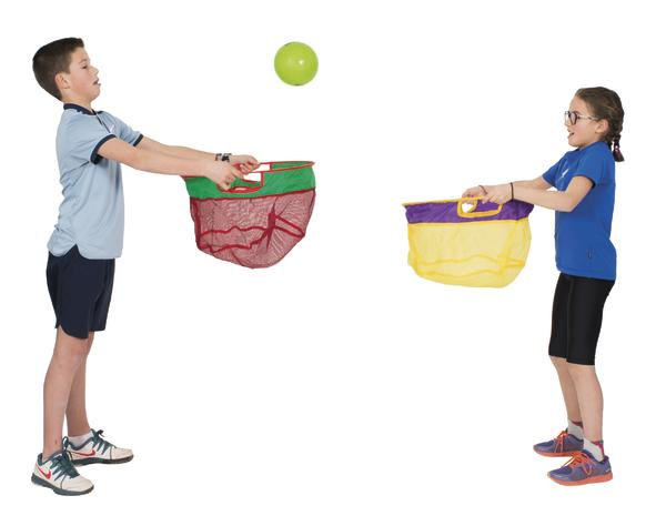Junge und Mädchen spielen mit Netzen und werfen grünen Ball hin und her.