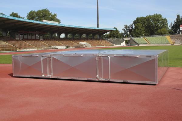 Podest für Siegerehrung auf einer Leichtathletikbahn im Stadion bei Tageslicht.