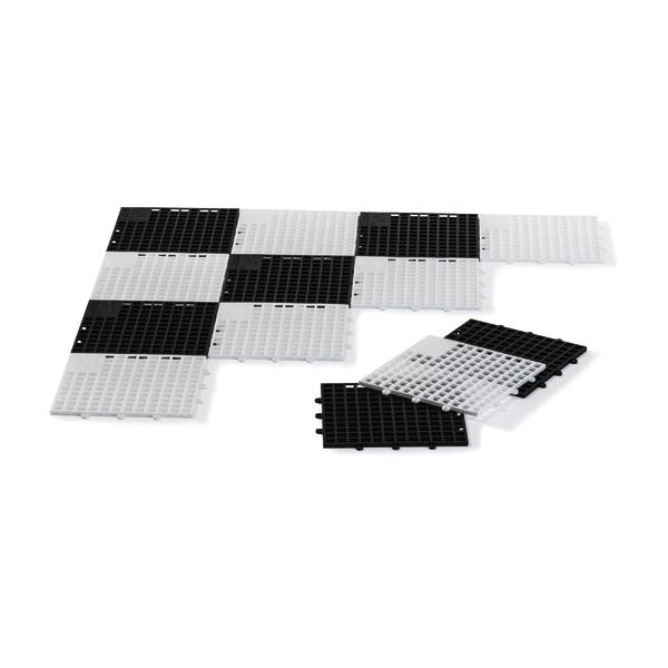 Schwarz-weiße modulare Kunststoffbodenplatten zum Verbinden und Verlegen auf weißem Hintergrund.