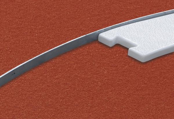 Weißes Startblock-Pad auf roter Tartan-Laufbahn mit Metallkante, Nahaufnahme.
