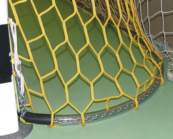 Nahaufnahme eines gelben Handballtors mit Netz und Metallrahmen auf grünem Hallenboden.