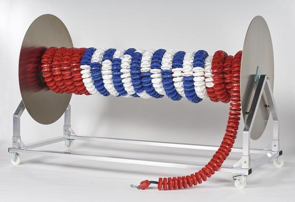 Optimierter  
Schwimmleinenrolle mit rot-weiß-blauen Bahnteilern auf Metallgestell mit Rollen.