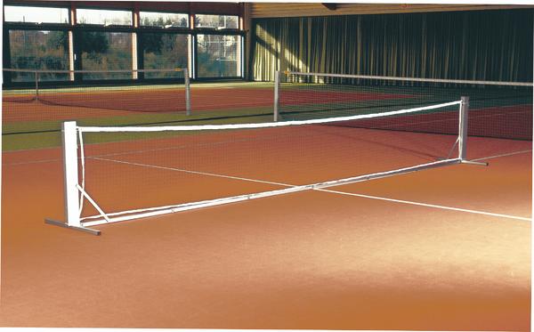 Tennisnetz auf rotem Hallen-Tennisplatz mit großen Fenstern im Hintergrund.