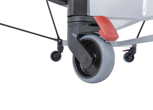 Rollstuhl-Rolle mit grauem Rad und roter Feststellbremse, Nahaufnahme auf weißem Hintergrund.