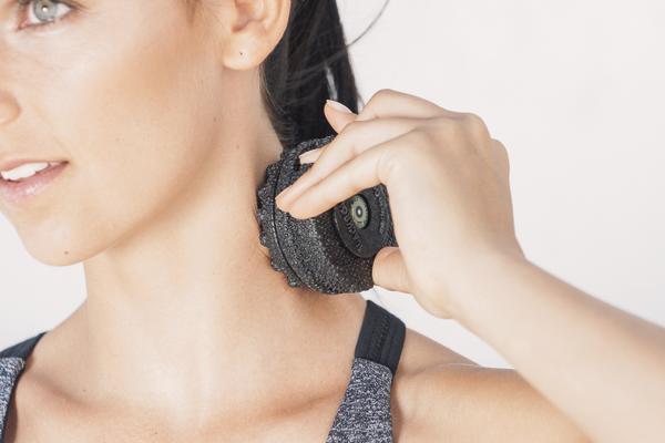 Frau nutzt Massagegerät zur Nackenentspannung, Nahaufnahme, weißer Hintergrund.