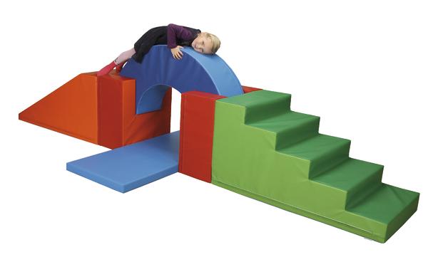 Kind liegt auf buntem Schaumstoff-Klettergerüst mit Treppe, Rampe und Bogen.