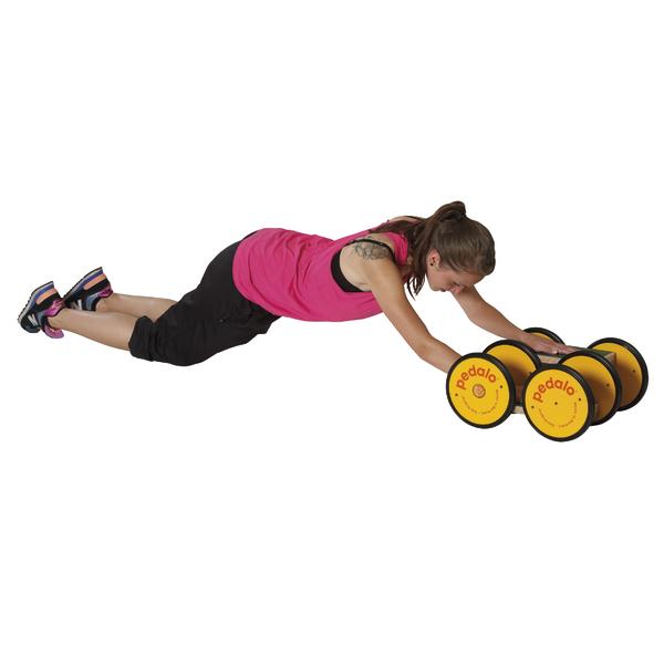 Frau trainiert mit gelbem Pedalo-Radroller für Arm- und Rumpfstabilität auf weißem Hintergrund.