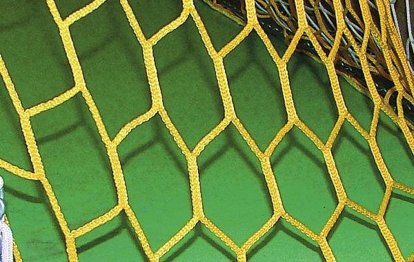 Nahaufnahme eines gelben Fußballtors mit grünem Spielfeld im Hintergrund.