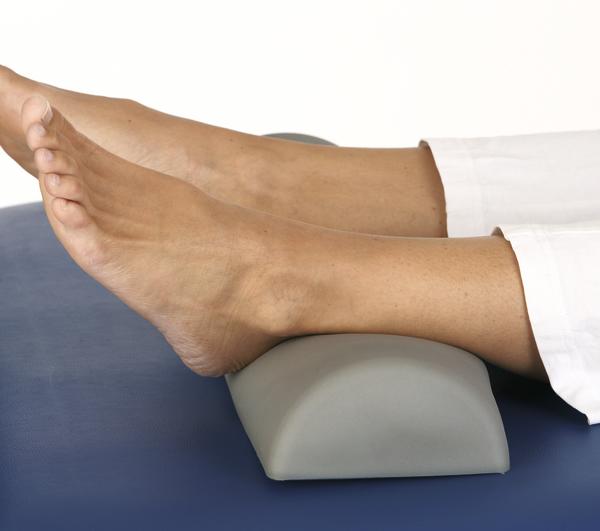 Beine mit Füßen auf ergonomischem Polster zur Entlastung und Unterstützung beim Liegen.