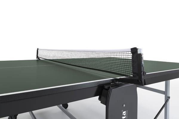 Tischtennisplatte mit Netz, grüne Spielfläche und schwarzer Rahmen, Nahaufnahme.