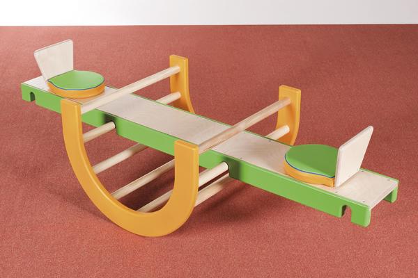 Kinderspielplatz-Wippe aus Holz mit grünen Sitzen und orangen Halterungen auf rotem Boden.