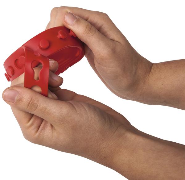 Hände halten und biegen ein rotes flexibles Silikonarmband mit Noppen.