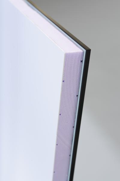 Nahe Aufnahme einer mehrschichtigen Sandwichplatte mit weißer Oberfläche und schwarzer Rückseite.