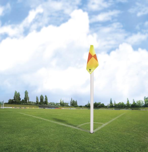 Eckfahne auf grünem Fußballfeld bei klarem Himmel mit weißen Spielfeldlinien.