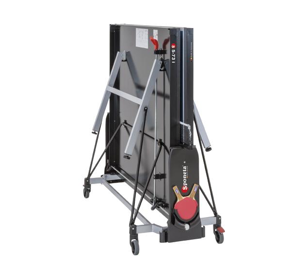 Zusammengeklappter Tischtennistisch auf Rollen mit stabilem Metallrahmen und Netzhalterung.