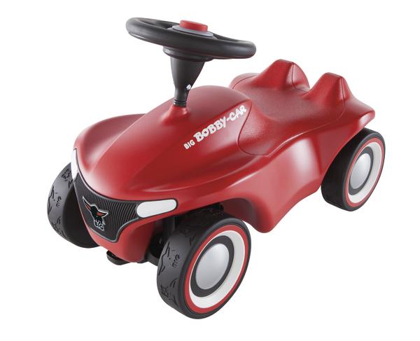Rotes Bobby-Car Kinderfahrzeug mit schwarzem Lenkrad und weißen Reifenrändern, Spielzeugauto.