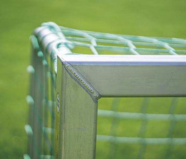 Aluminium-Torrahmen mit grünem Netz auf Fußballrasen, Nahaufnahme der Ecke.