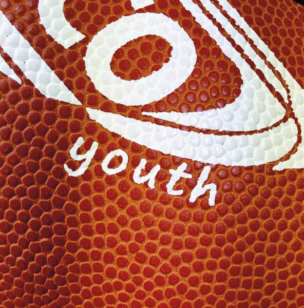 Detailaufnahme eines braunen SPORTCO Youth Gummi-Footballs mit stark genoppter Oberfläche und weißem Logo-Aufdruck im klassischen American-Football-Design
