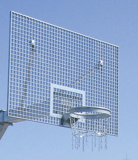Basketballkorb mit Metallnetz und transparentem Gitter-Rückbrett vor blauem Himmel.