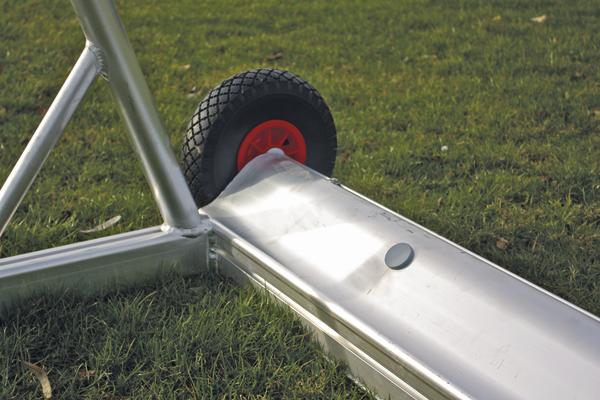 Robustes Metallgestell mit Rad auf Grasfläche, Teil eines mobilen Sporttors.