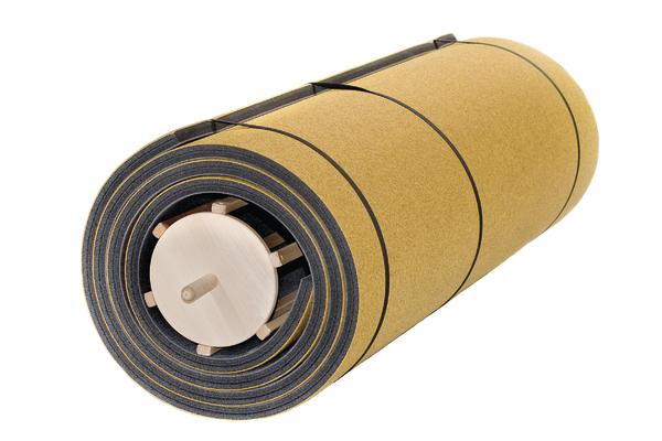 Aufgerollte Bodenturnmatte in Gelb mit dunkler Unterseite auf einem Holz-Aufrollkern und schwarzen Tragegurten.