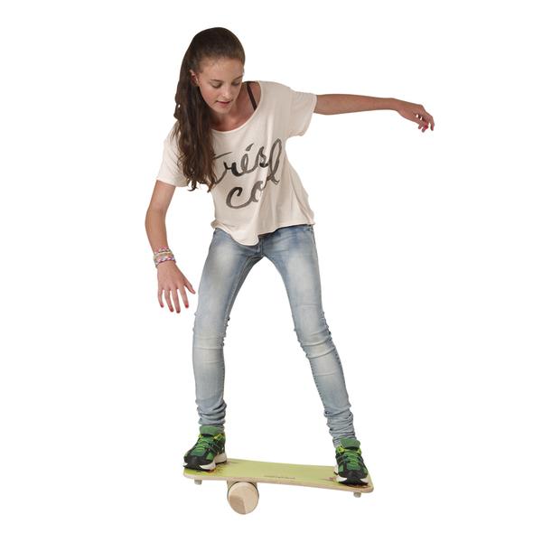 Mädchen balanciert auf einem Skateboard-ähnlichen Brett auf einer Rolle, Indoor-Übung.